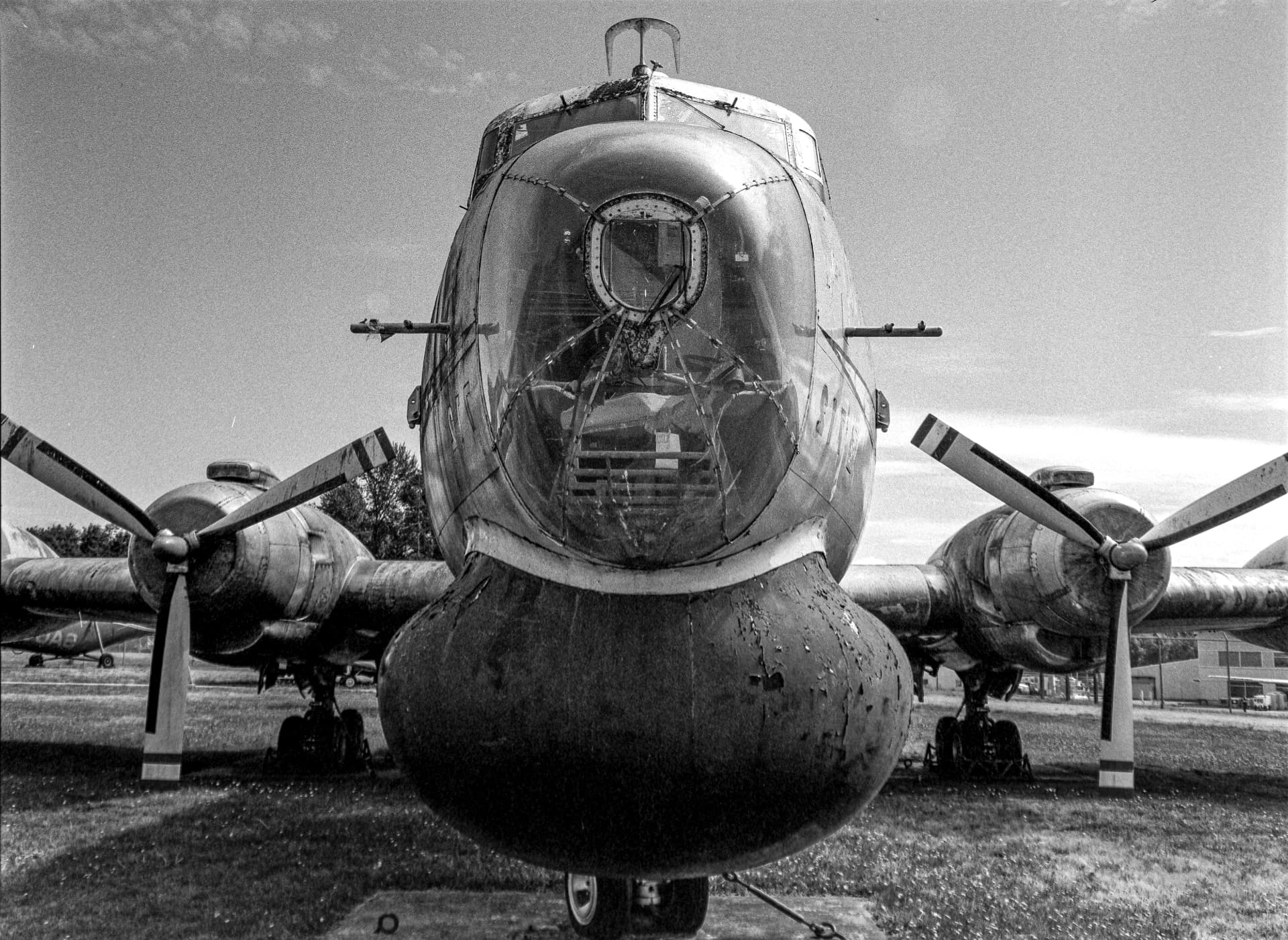 Machine Gun Plane — the glazed nose and propellers of a grounded aircraft
