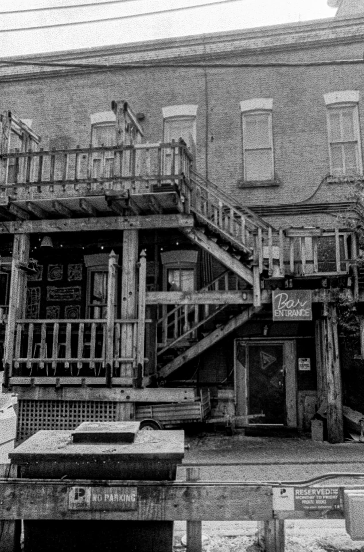 Downtown — a timber staircase and balcony against a brick building facade