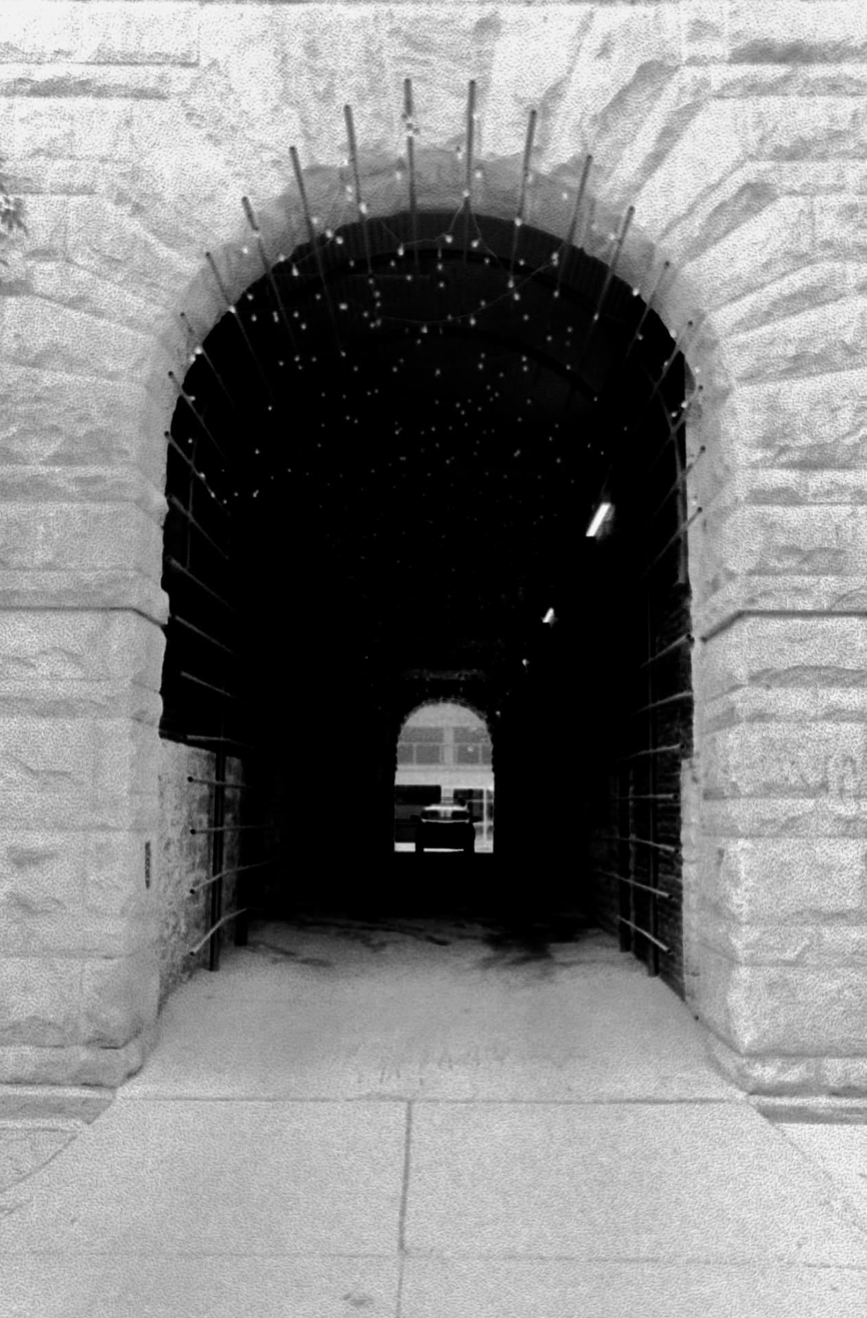 Tunnel Car — a stone archway passage framing a distant parked car